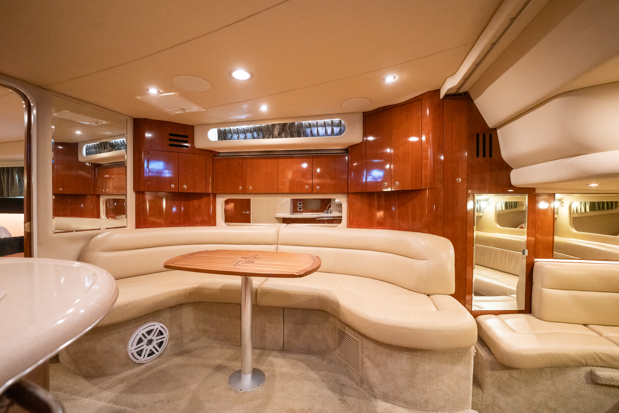 Below-deck salon dinette with curved seating and wood cabinetry